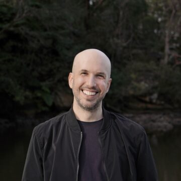 Portrait eines jungen, weißen Mannes mit Glatze in schwarzem Hemd, es ist Komponist Charlie Sdraulig.