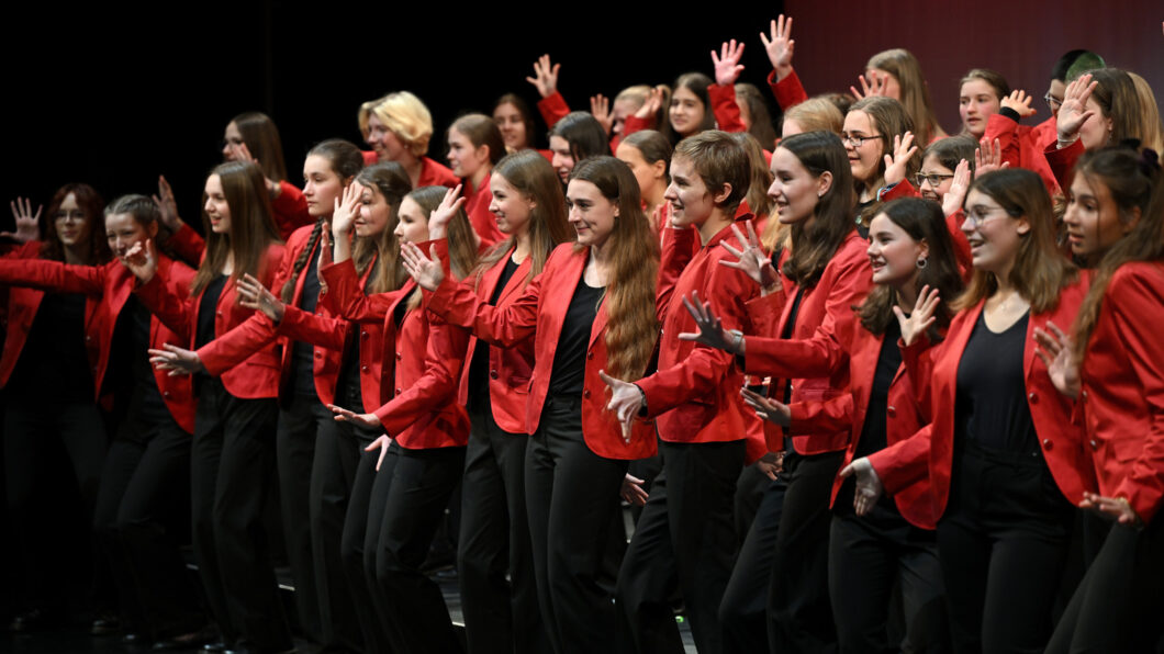 Mädchen in roten Jacketts singen, es ist der Mädchenchor Hannover.