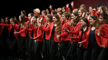 Mädchen in roten Jacketts singen, es ist der Mädchenchor Hannover.