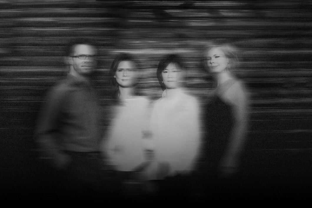Ein verschwommenes Schwarz-Weiß-Foto von vier Personen.