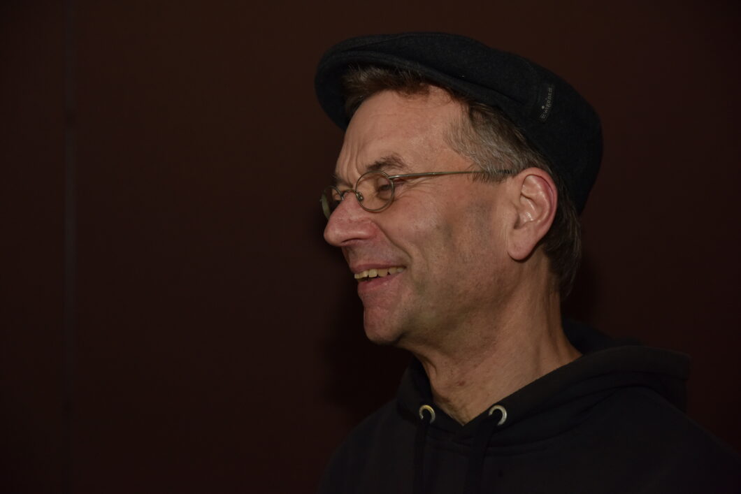 Ein lachender Mann mit Brille im Profil, es ist Komponist Joachim Heintz.