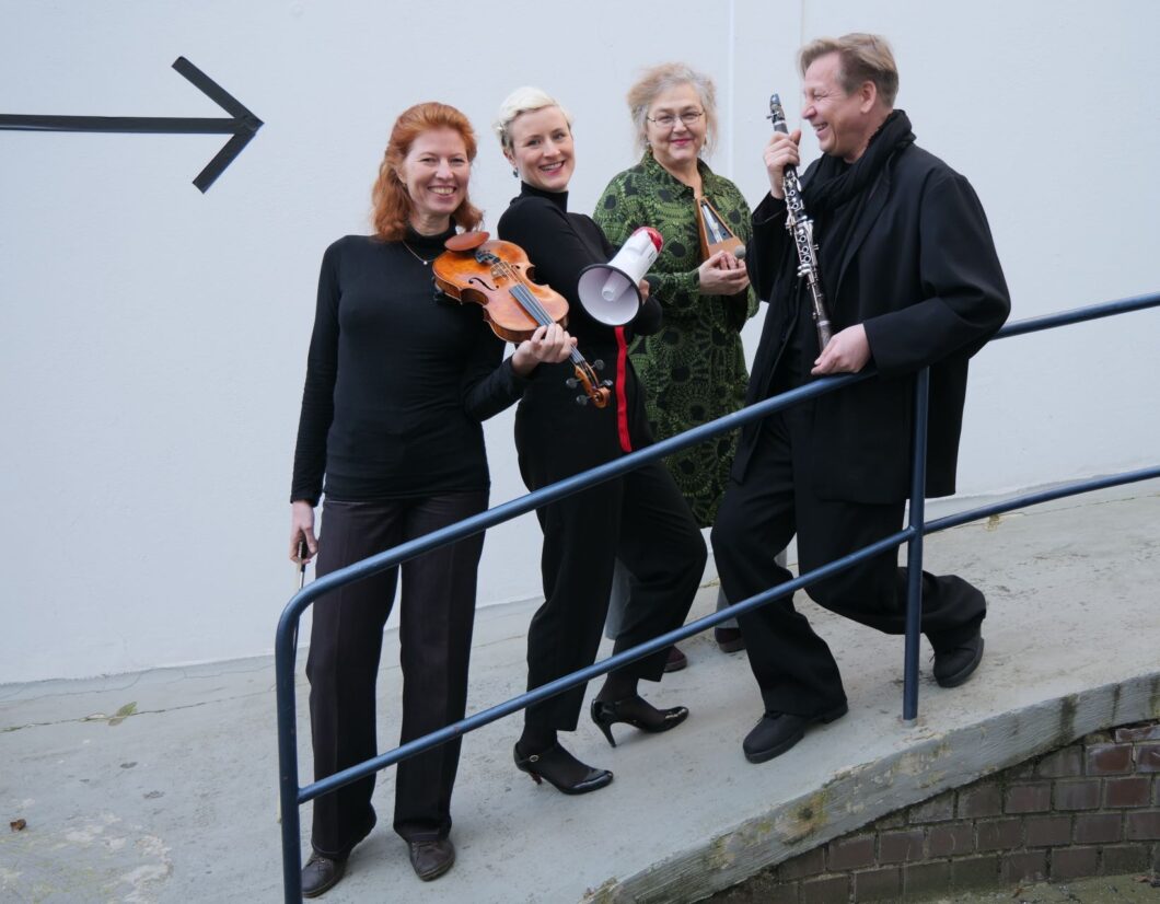Vier Musikerinnen und Musiker stehen an einem Geländer mit ihren Instrumenten in der Hand.